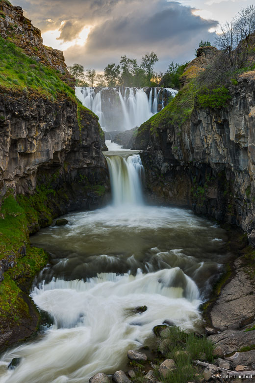 The White River thunders over White River Falls into a canyon lined by basalt walls covered in vibrant green moss before dropping over the smaller Celestial Falls on its journey downstream at Falls River State Park, Oregon.